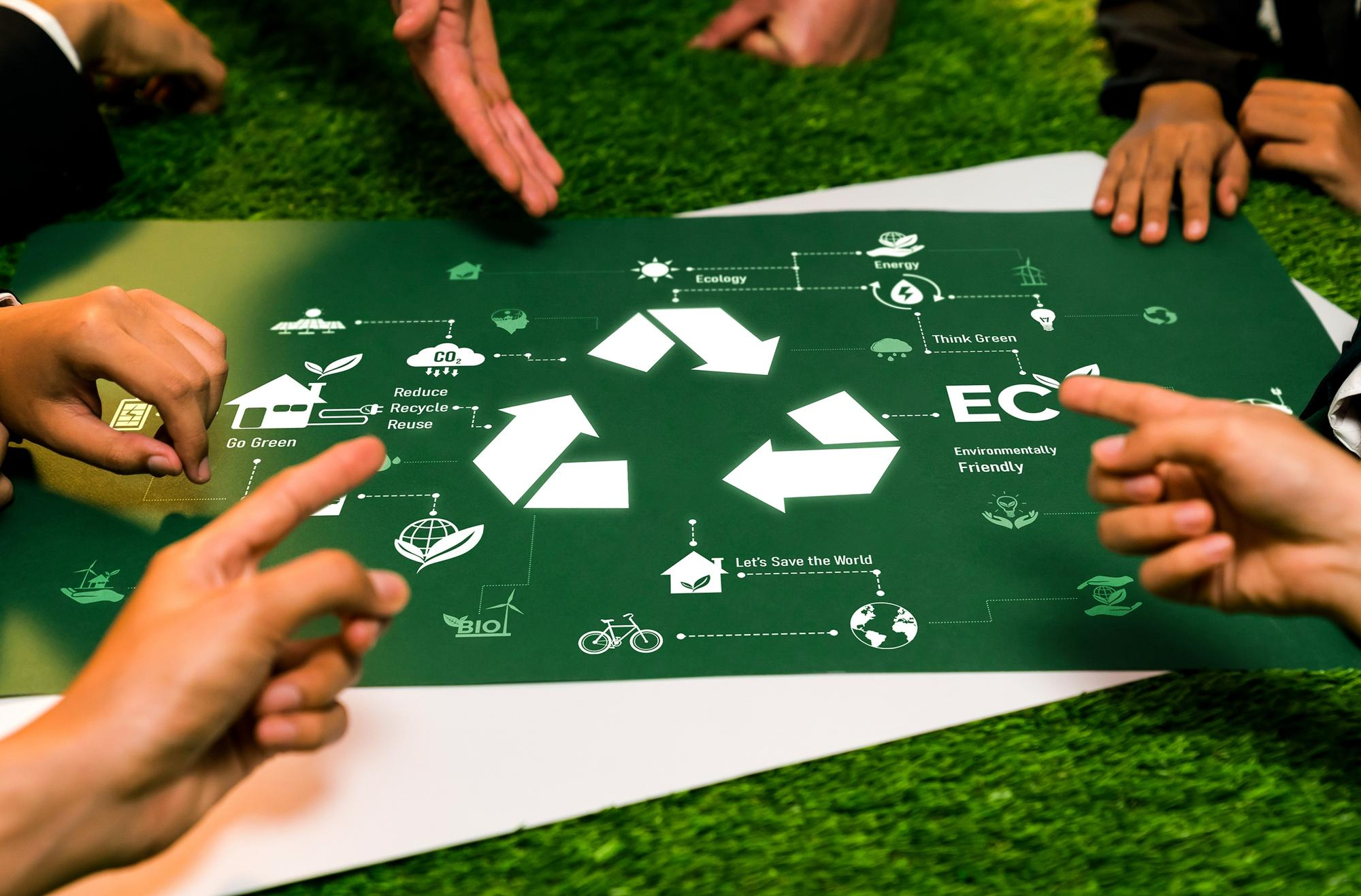 Dłoń wskazująca na planszę z ikoną recyclingu i napisem ECO.